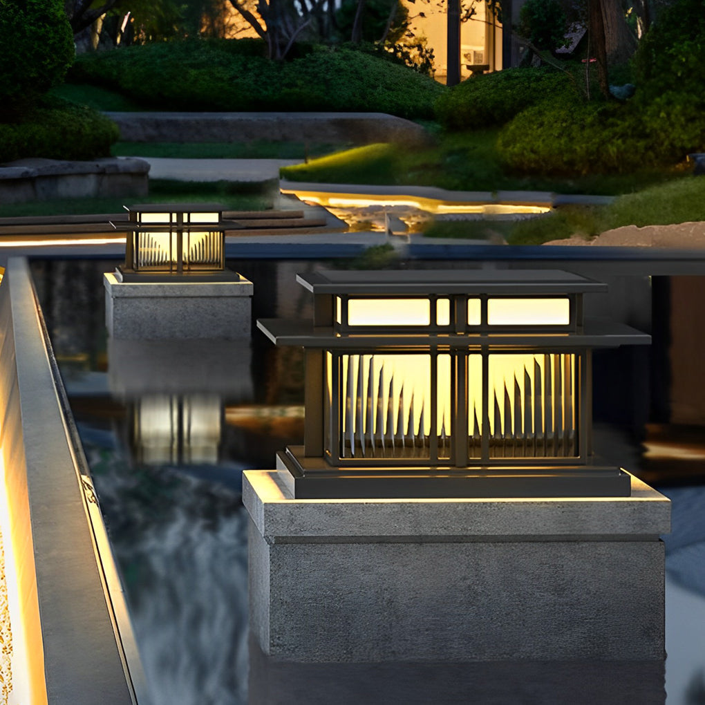 Modern porch pillar lights installed beside a water feature, providing warm ambient outdoor illumination.
