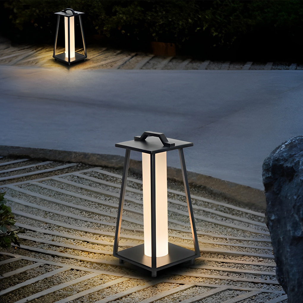 Modern portable outdoor lantern placed along a driveway creating subtle ambient nighttime lighting.