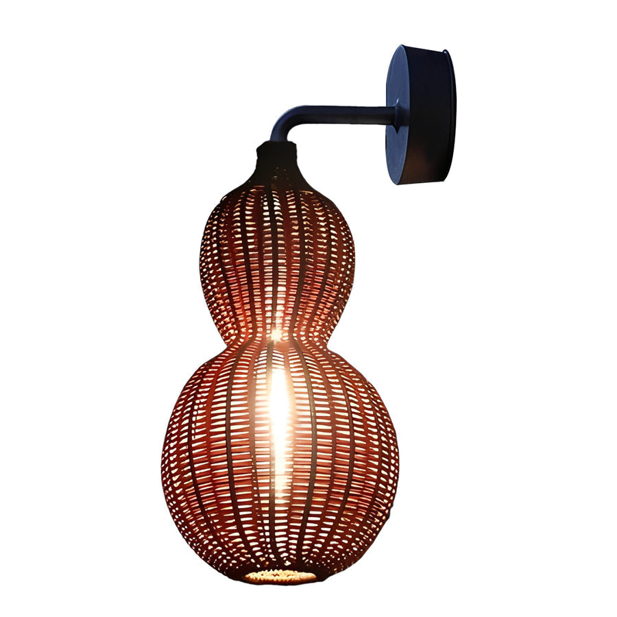 Modern rattan pendant light installed near a brick wall and window, enhancing outdoor architecture with warm tones.