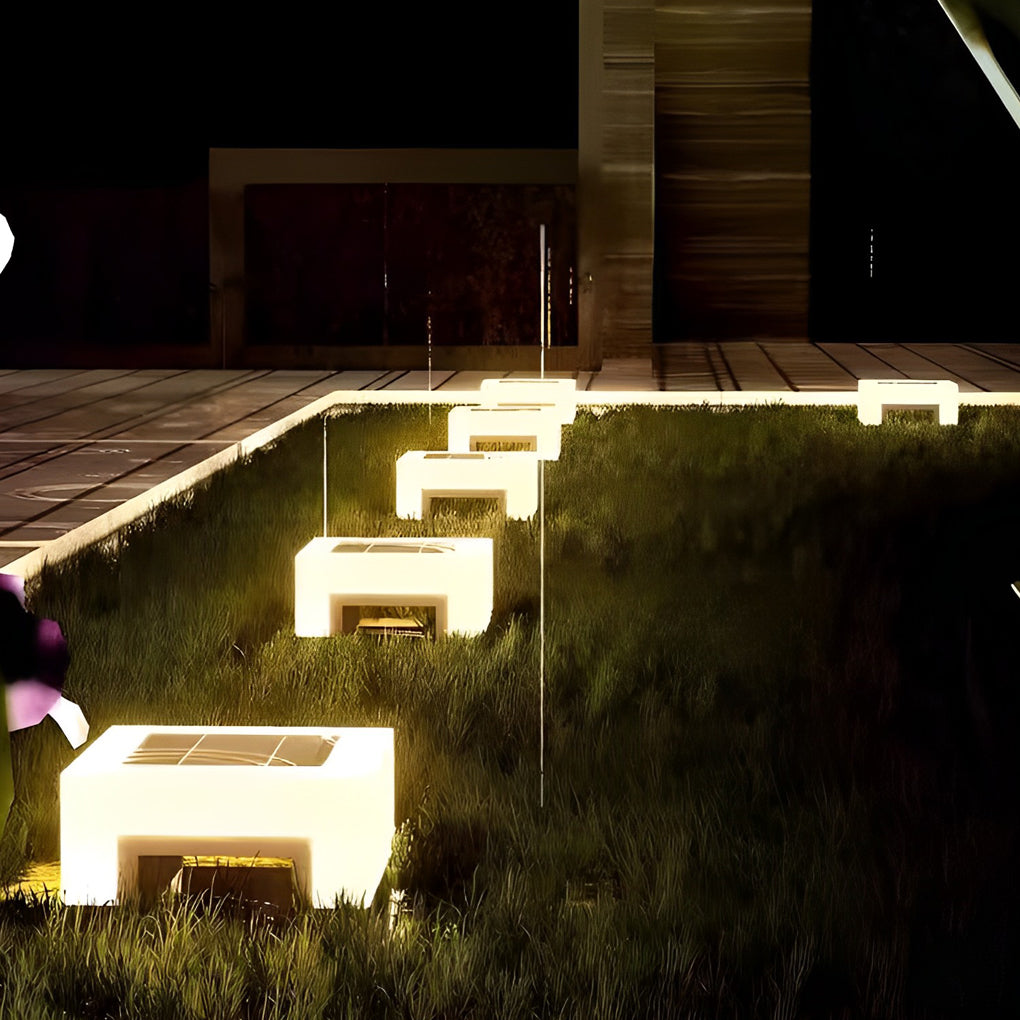 Modern solar lawn lights creating glowing pathway effect in landscaped yard.