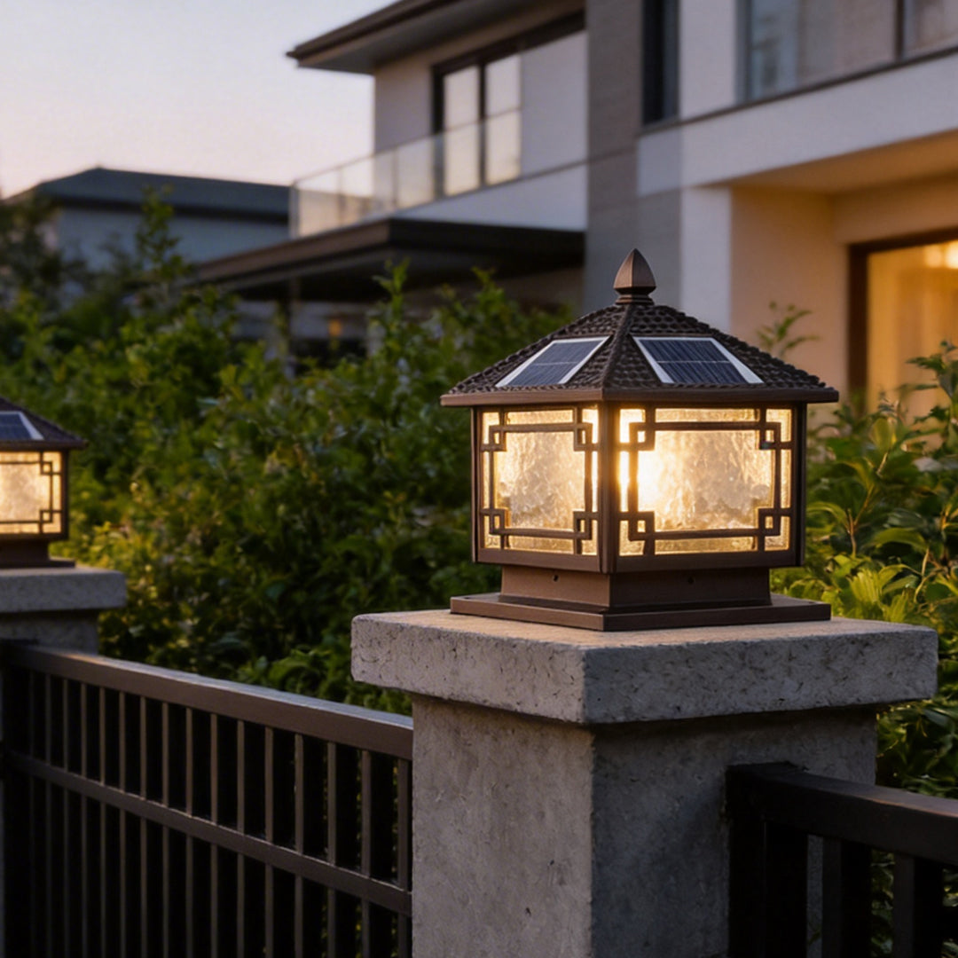 Modern solar outdoor garden pillar lights glowing on a concrete pillar at a luxury villa gate.