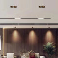 Modern living room using adjustable square LED downlights to create a warm wall-wash effect on a wood-slat wall.