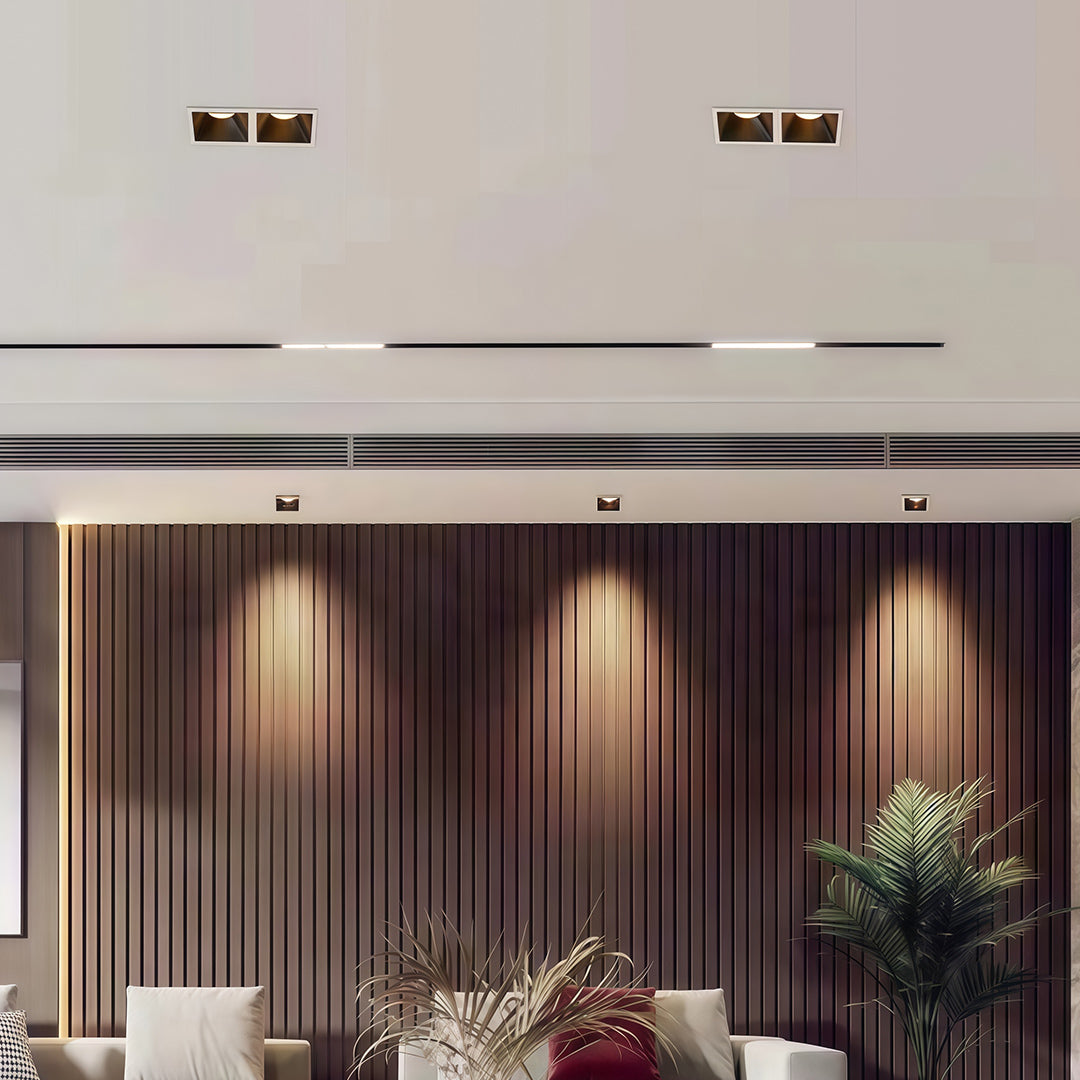 Modern living room using adjustable square LED downlights to create a warm wall-wash effect on a wood-slat wall.
