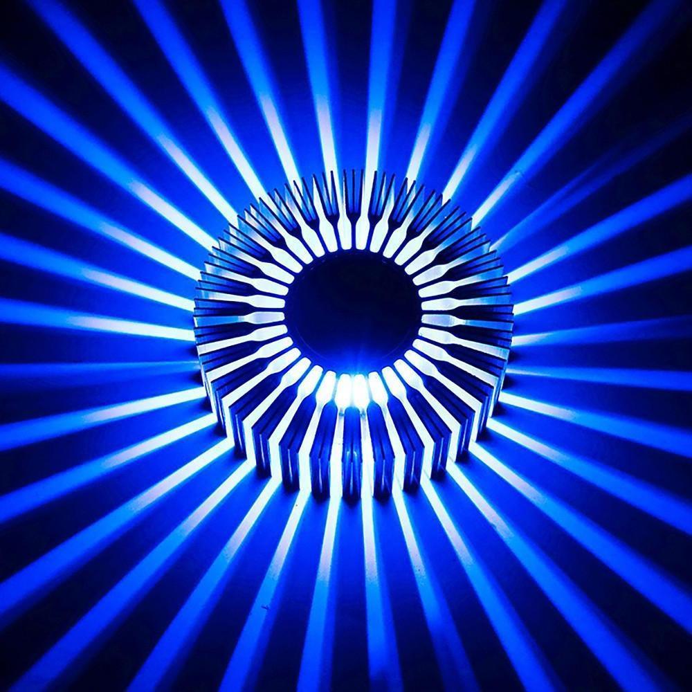 Modern sunburst ceiling fixture illuminating a living space with vibrant blue light.