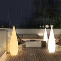 Modern teardrop outdoor light illuminating garden pathway with soft ambient glow.