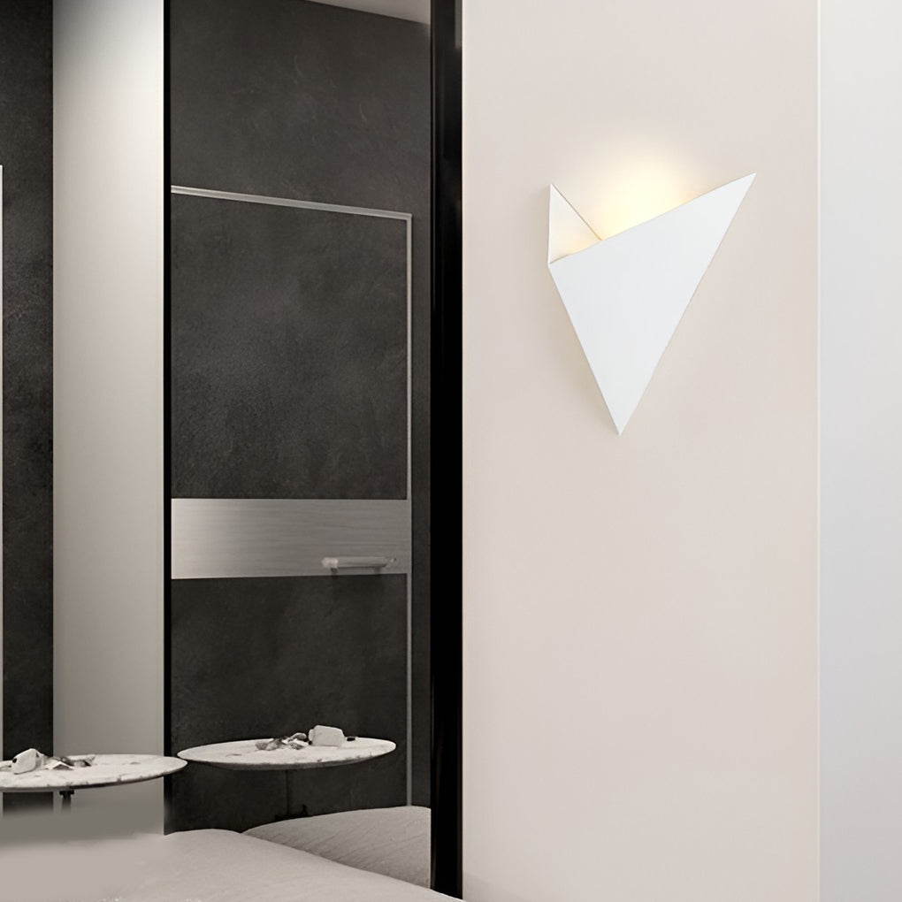 Modern triangle wall sconce with close-up of its geometric design and light output.