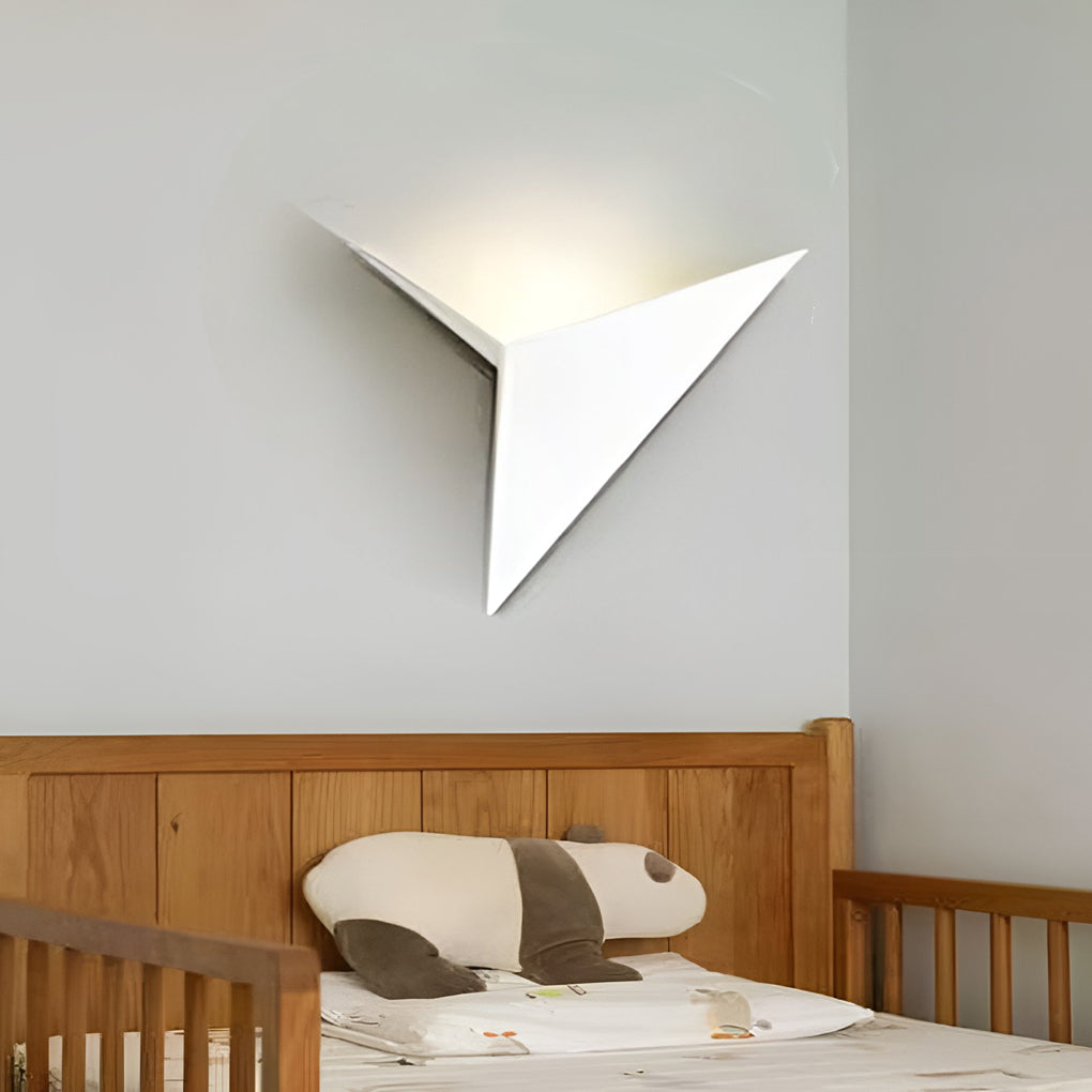 Modern triangle wall sconce illuminating a minimalist interior with focused glow.