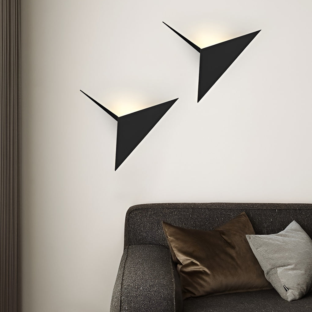 Modern triangle wall sconce enhancing a modern bedroom with warm light.
