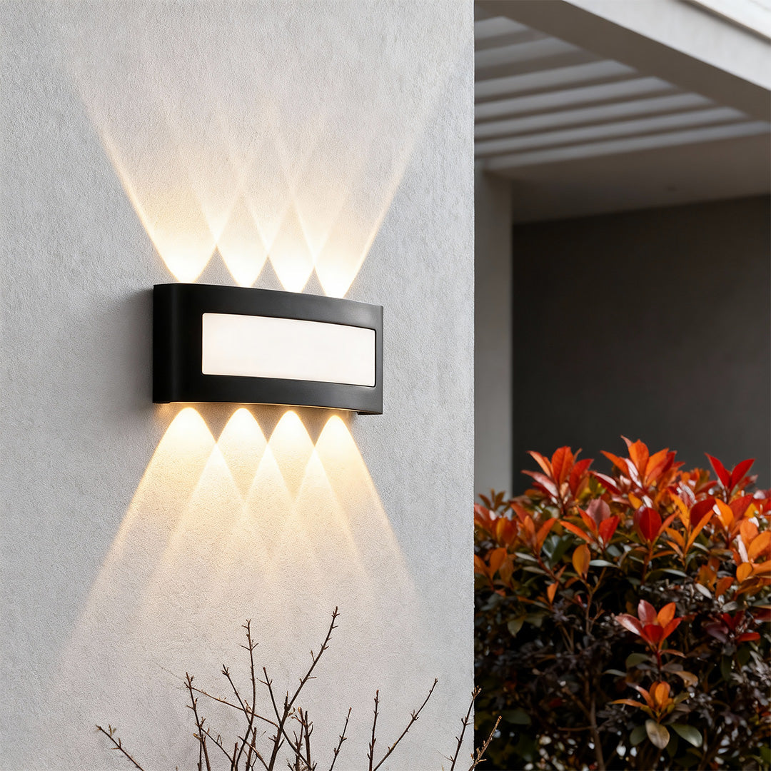 Modern up down wall lights featuring glass shade chandelier styling creating dramatic bidirectional light spread on textured wall.