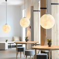 Moon globe pendant light set installed in modern dining space with wood accents.