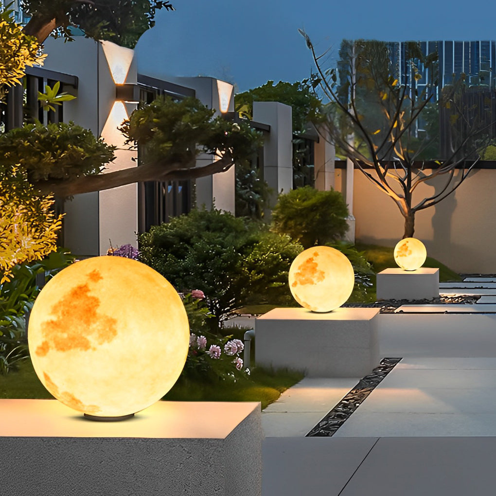 Moon-shaped stone pillar light creating ambient lighting for modern house entrance.