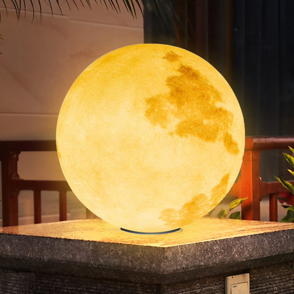 Moon-shaped stone pillar light illuminating brick pathway with decorative plants.