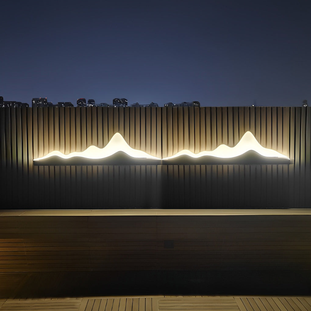 Mountain LED wall light with a sleek design, illuminating a modern garden at night.