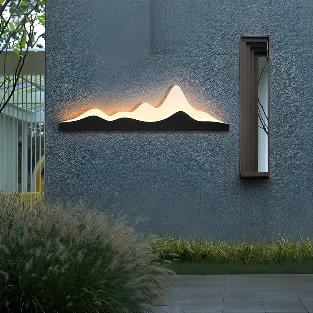 Mountain LED wall light providing soft illumination to a minimalist outdoor space.