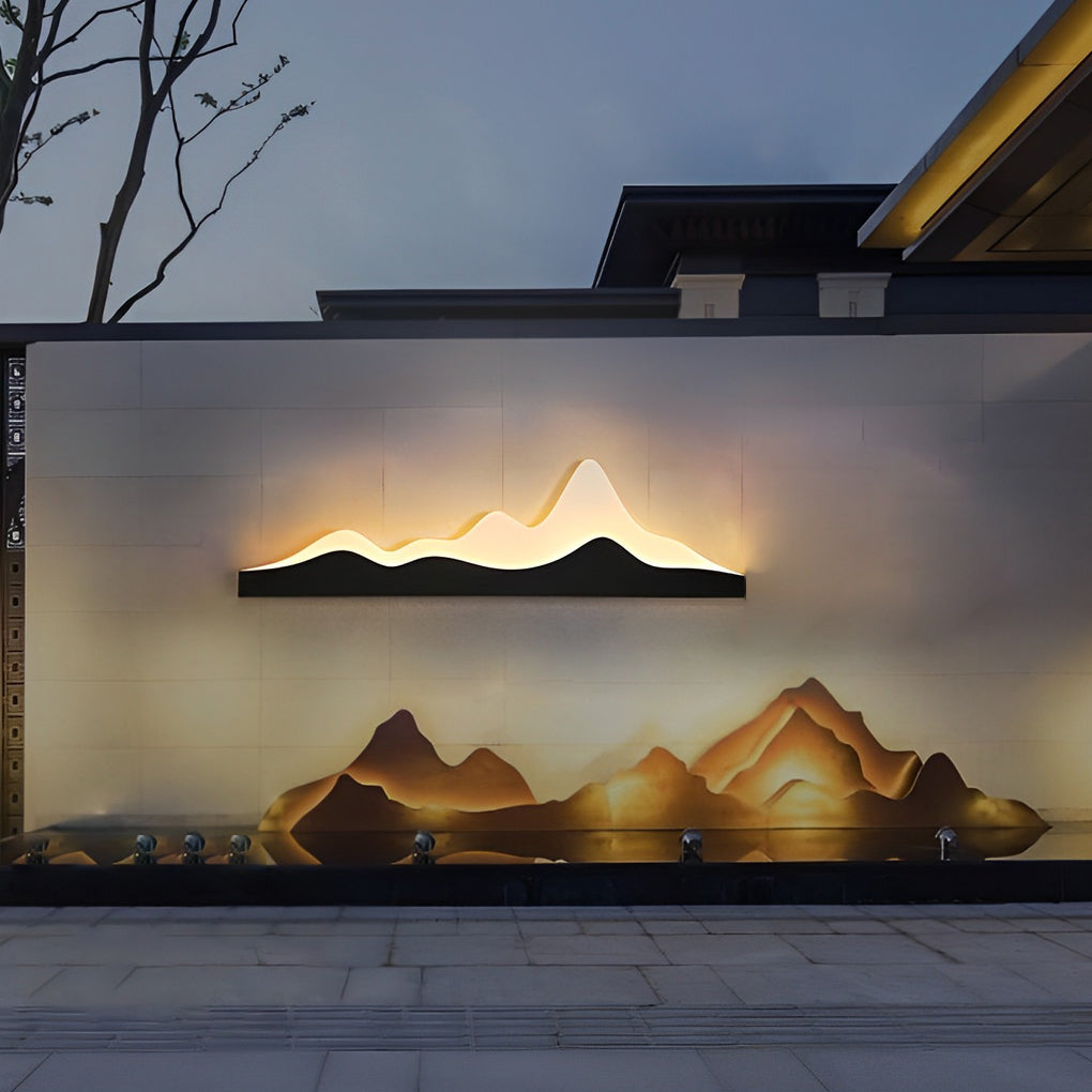 Mountain LED wall light creating a striking silhouette against a textured outdoor wall.