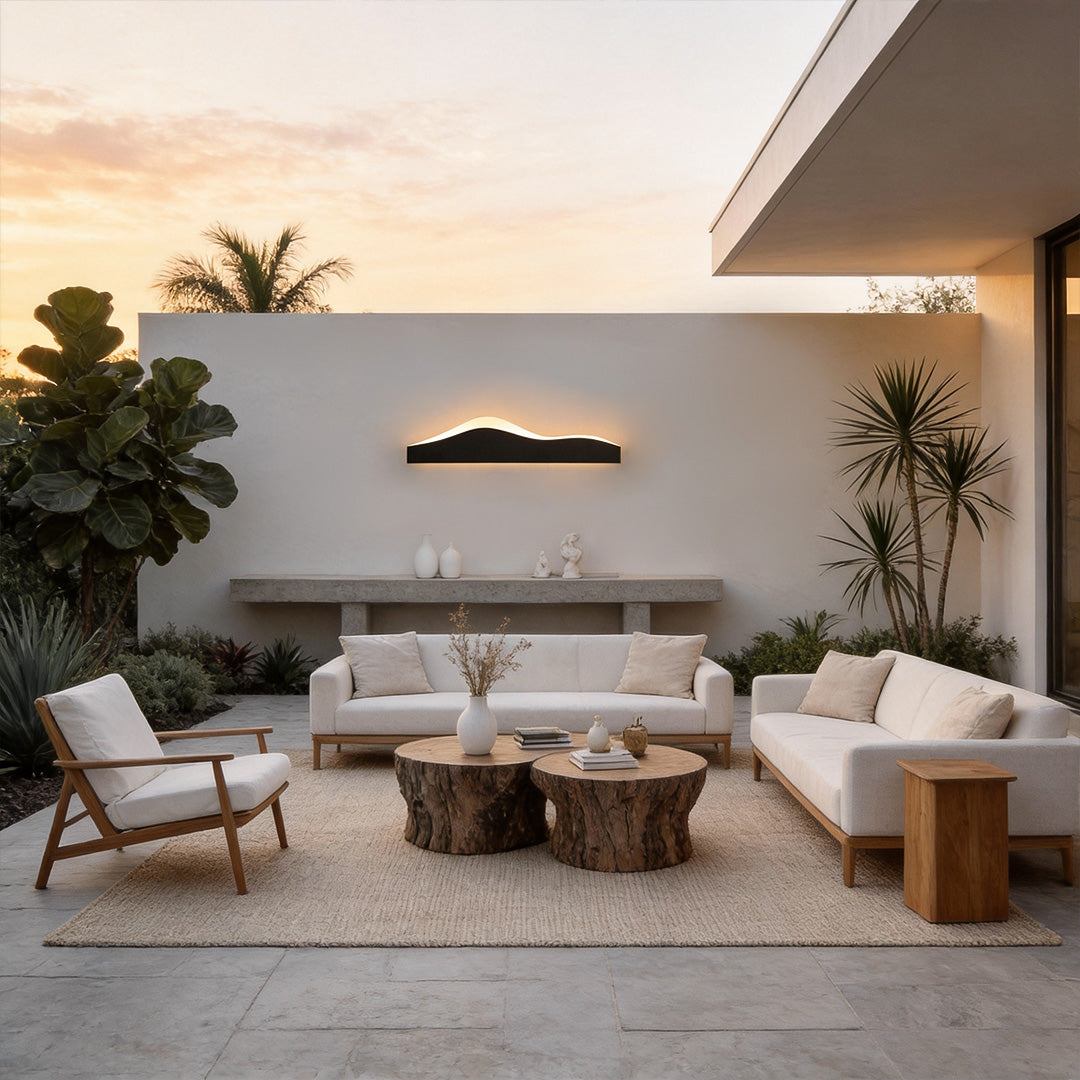 Mountain LED wall light casting warm light over a cozy outdoor lounge with wooden furniture.