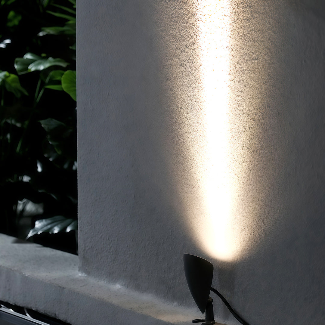 Narrow beam of light projected upward by a small decorative wall wash lighting.