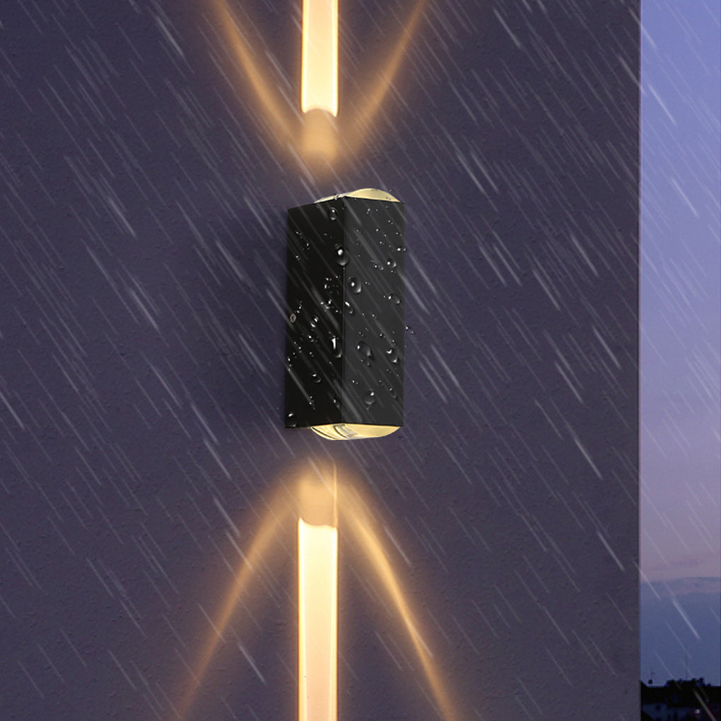 Close-up of a narrow beam wall sconce in rainy conditions, showing focused vertical light beams and weather-resistant design.