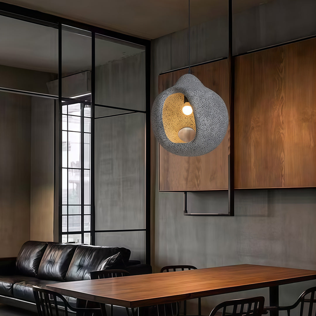 Nordic wabi sabi pendant light above wooden dining table in cozy minimalist home interior.