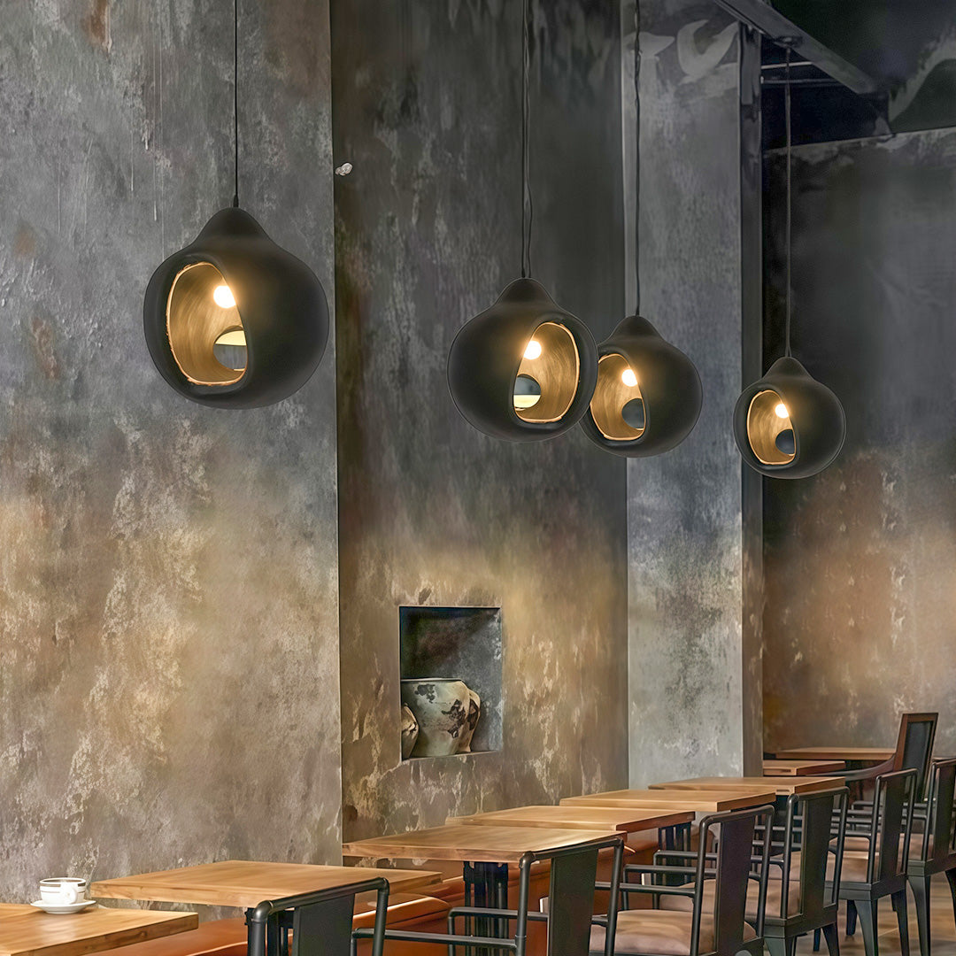 Nordic wabi sabi pendant light in a rustic café setting, casting warm ambient glow on textured concrete wall.