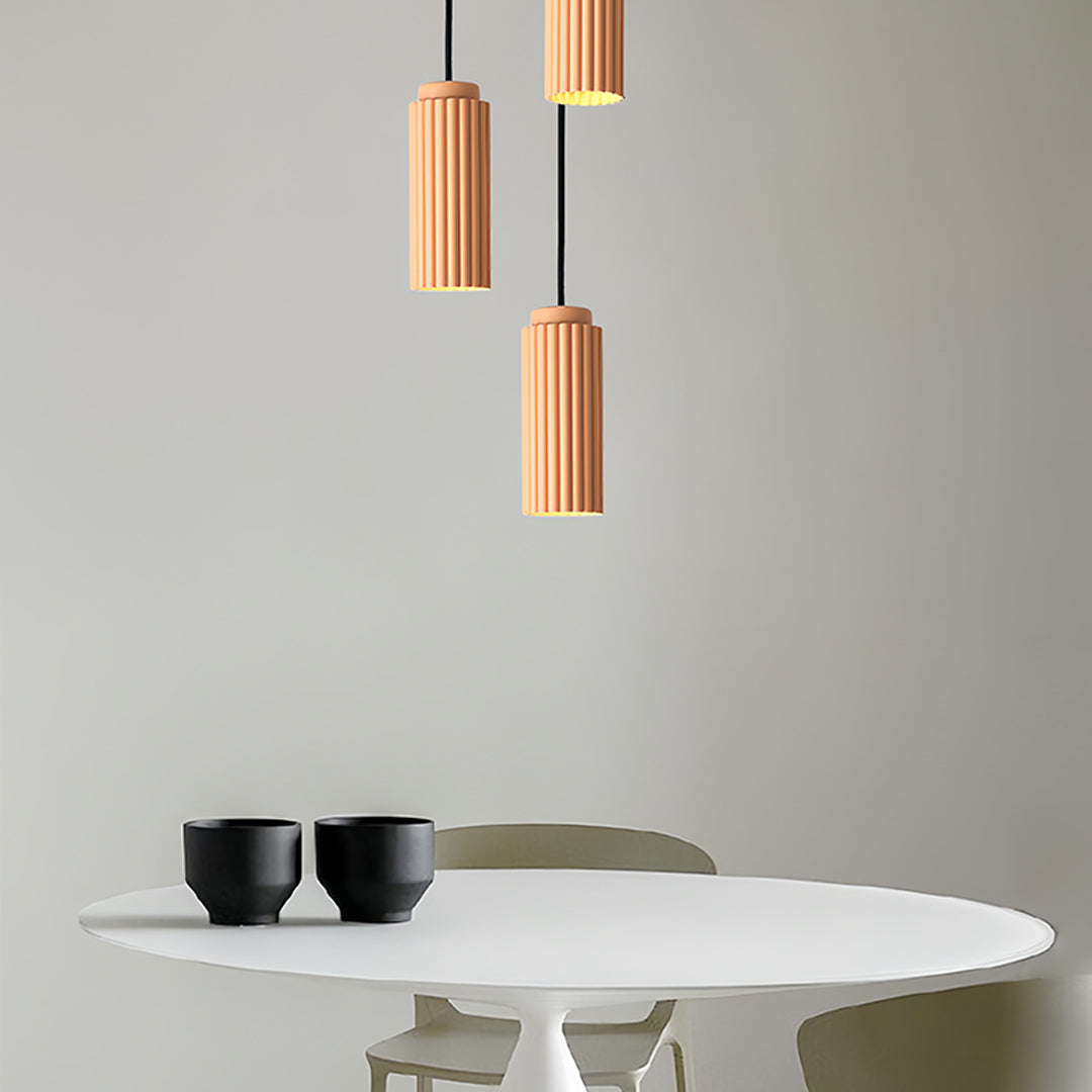 Orange metal pendants light with white metal accents on marble surface