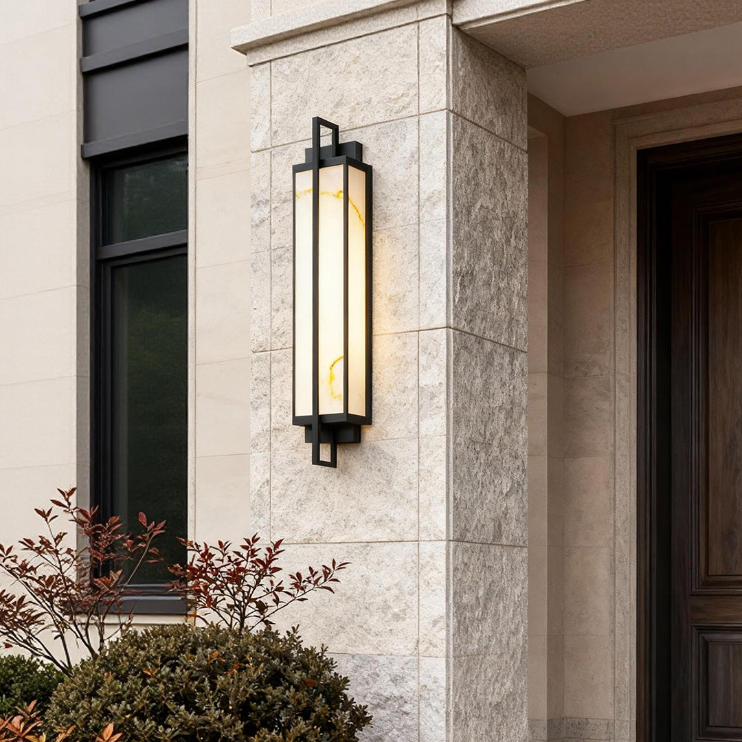 Outdoor alabaster wall sconces mounted on stone exterior, casting warm light beside entrance.