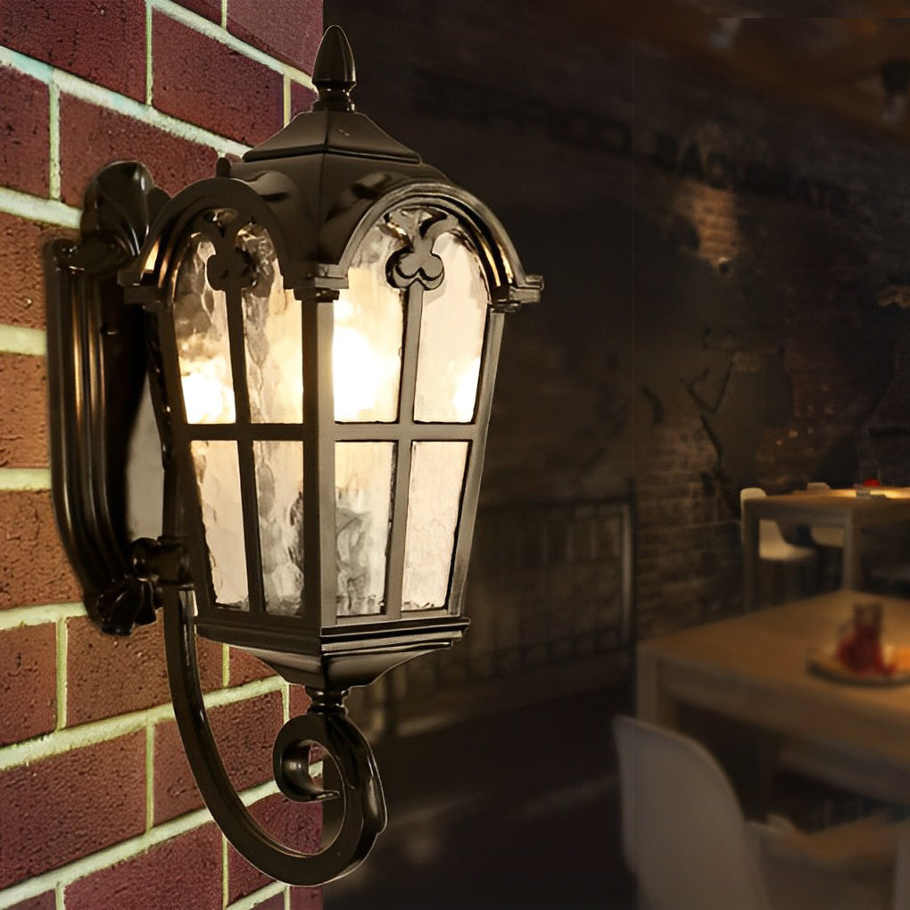 Outdoor black sconce with a vintage design, casting a soft glow on a stone wall.