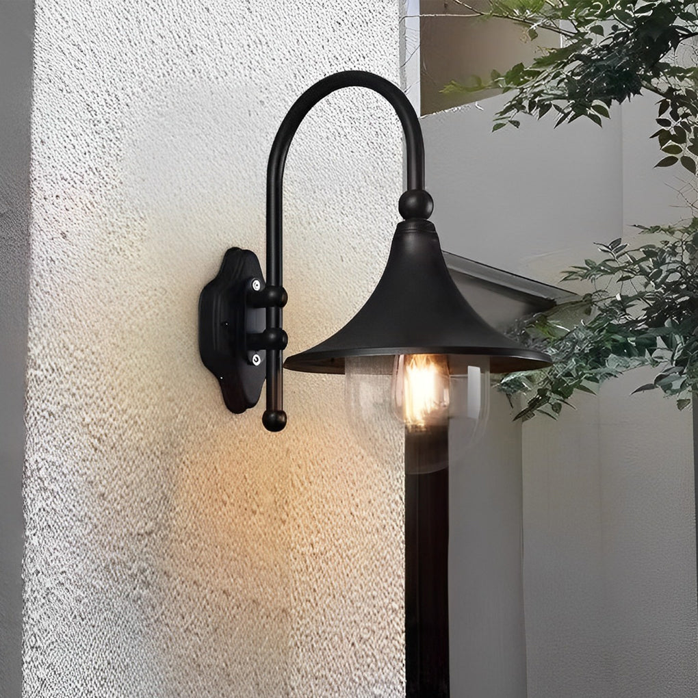 Outdoor black wall light with a curved arm, illuminating a white exterior wall.