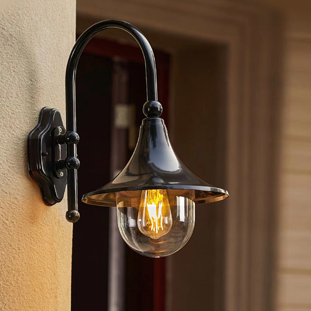 Outdoor black wall light with a rustic finish, providing ambient lighting near a wooden door.