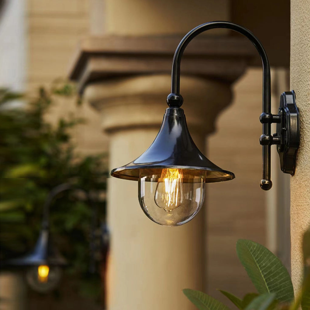 Outdoor black wall light with a vintage style, casting soft light on a beige wall.