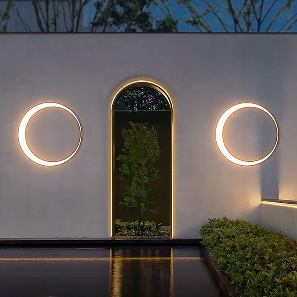 Outdoor cylinder wall light installed near an arched doorway, providing balanced circular illumination on a minimalist exterior wall.