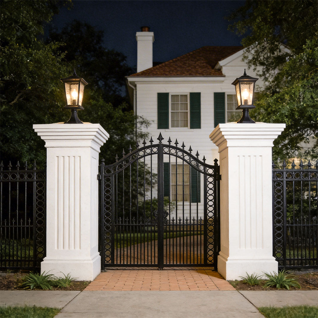 Outdoor driveway pillar lights with a vintage design, enhancing a white gate entrance.