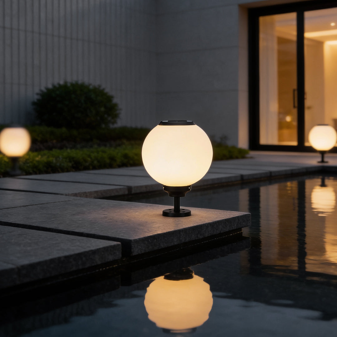 Outdoor gate pillar light with a spherical shape, installed on a stone pillar for a modern and inviting entrance.