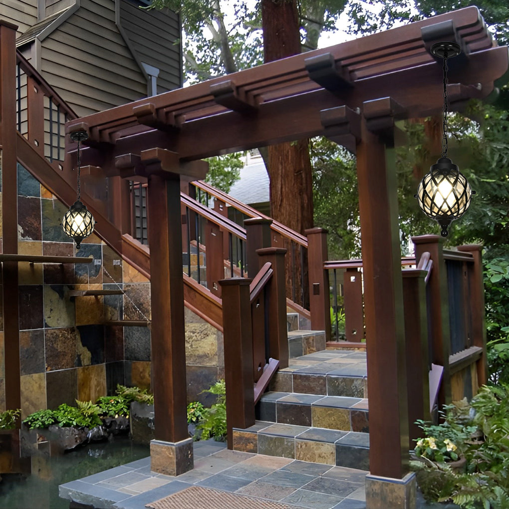 Outdoor globe pendant light hanging from a wooden pergola along garden steps.