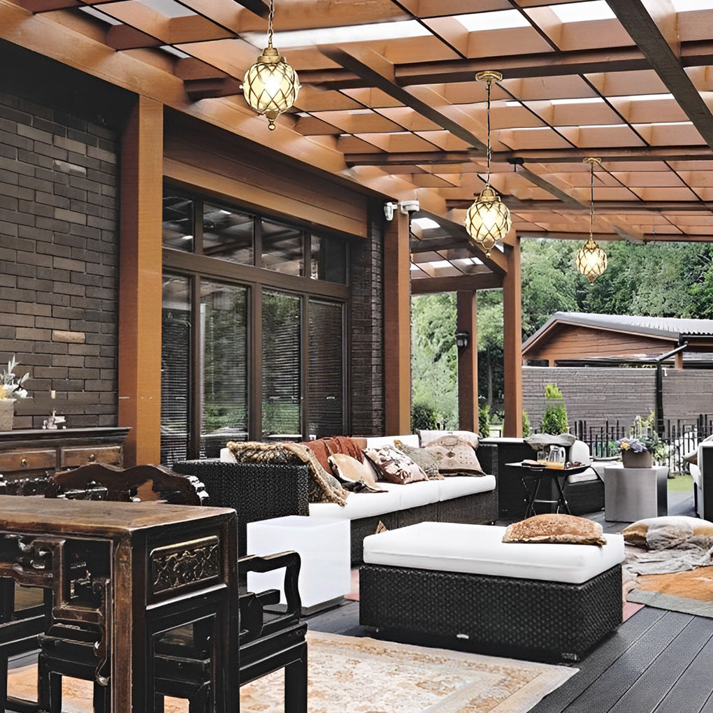 Multiple globe pendant lights illuminating a spacious outdoor living and dining area.