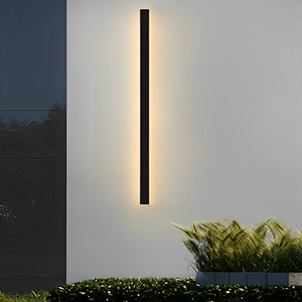 Outdoor linear wall light casting soft vertical illumination on minimalist exterior wall at night.