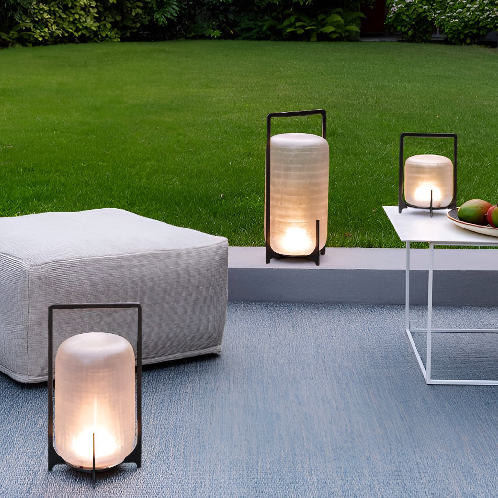 Outdoor modern handle lantern with frosted glass shade on wooden deck with cozy seating.