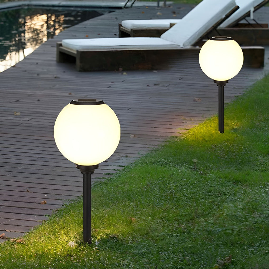 Outdoor path light globe illuminating a cozy outdoor deck with directional glow.