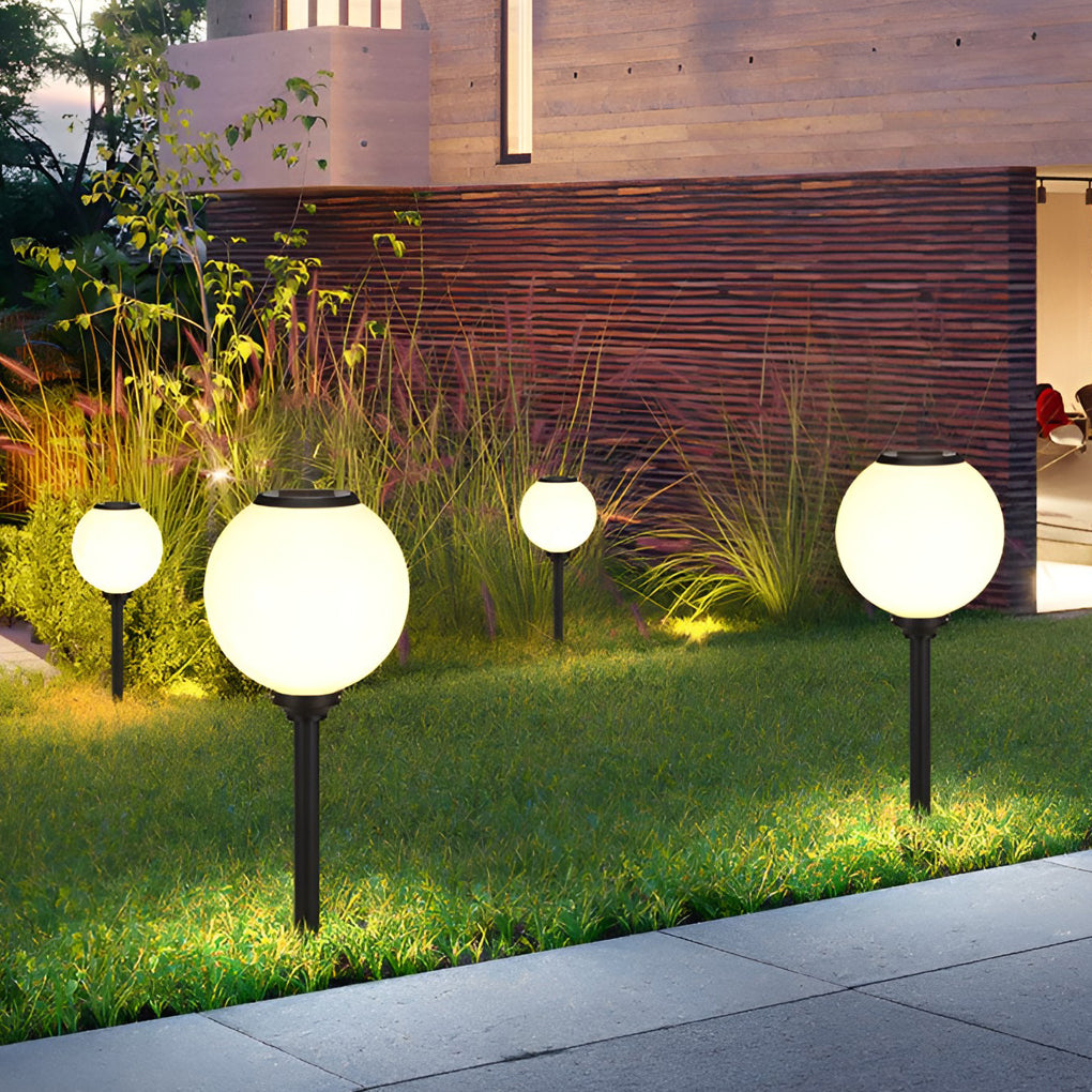 Outdoor path light globe enhancing a modern driveway with warm light.