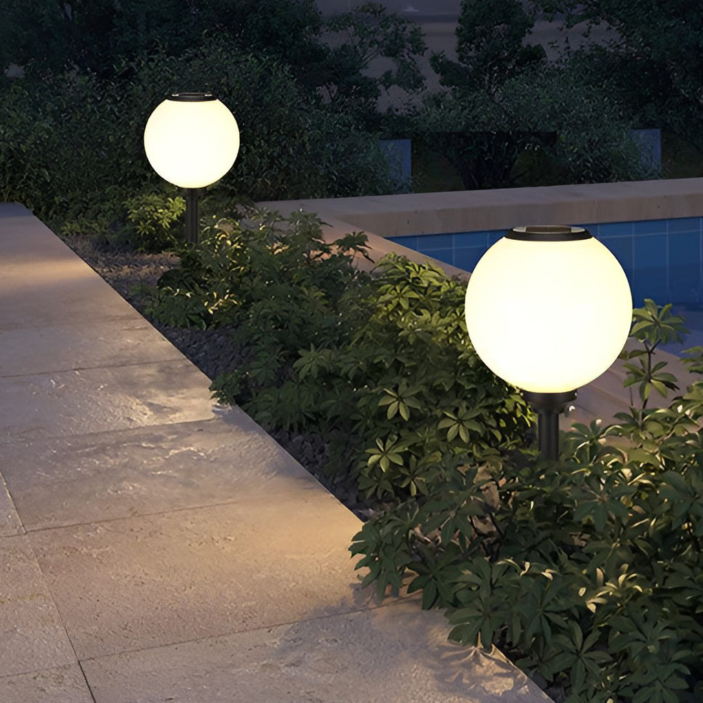 Outdoor path light globe enhancing a stylish outdoor seating area with ambient light.