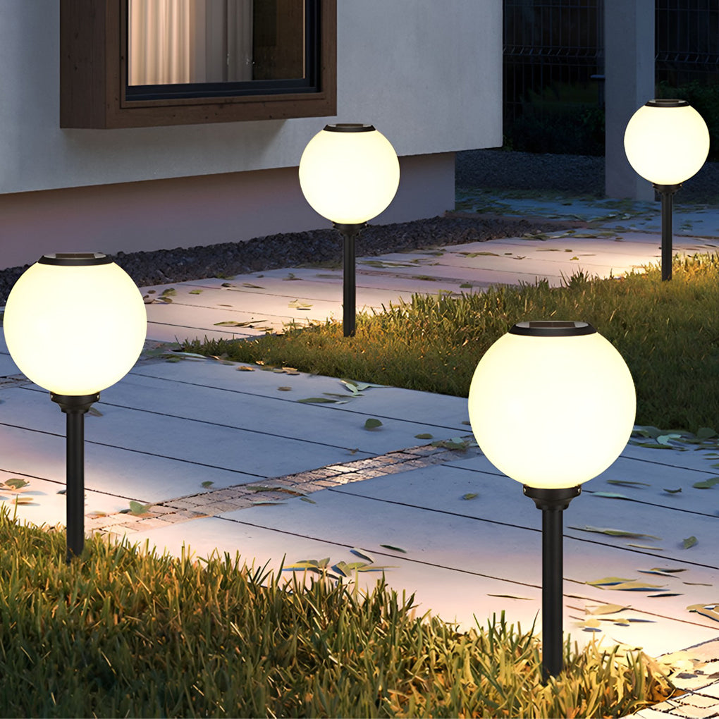 Outdoor path light globe providing soft illumination along a stylish stone staircase.