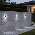 Outdoor patio solar lights mounted on a stone wall, providing elegant and energy-efficient illumination for garden pathways.
