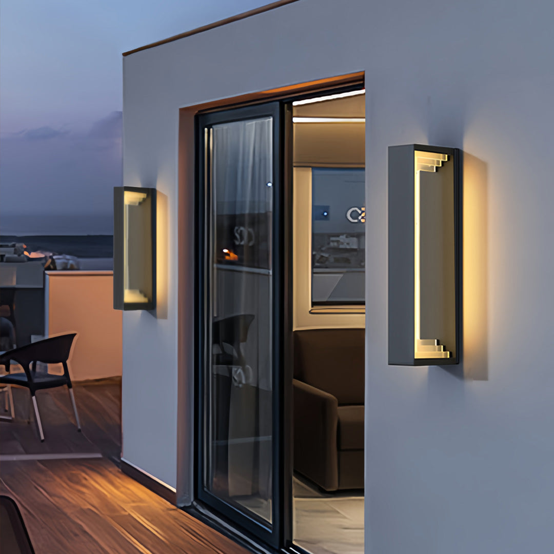 Outdoor sconce modern wall light installed near a sliding door, giving warm ambient lighting to a deck area.