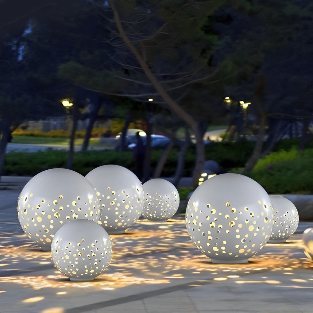 Outdoor sphere light with a white finish, providing ambient light near a driveway.