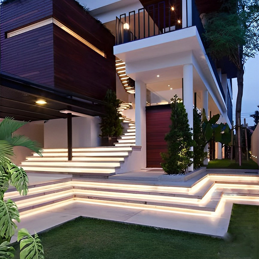 Outdoor stair lighting strips providing warm light along a stone staircase.