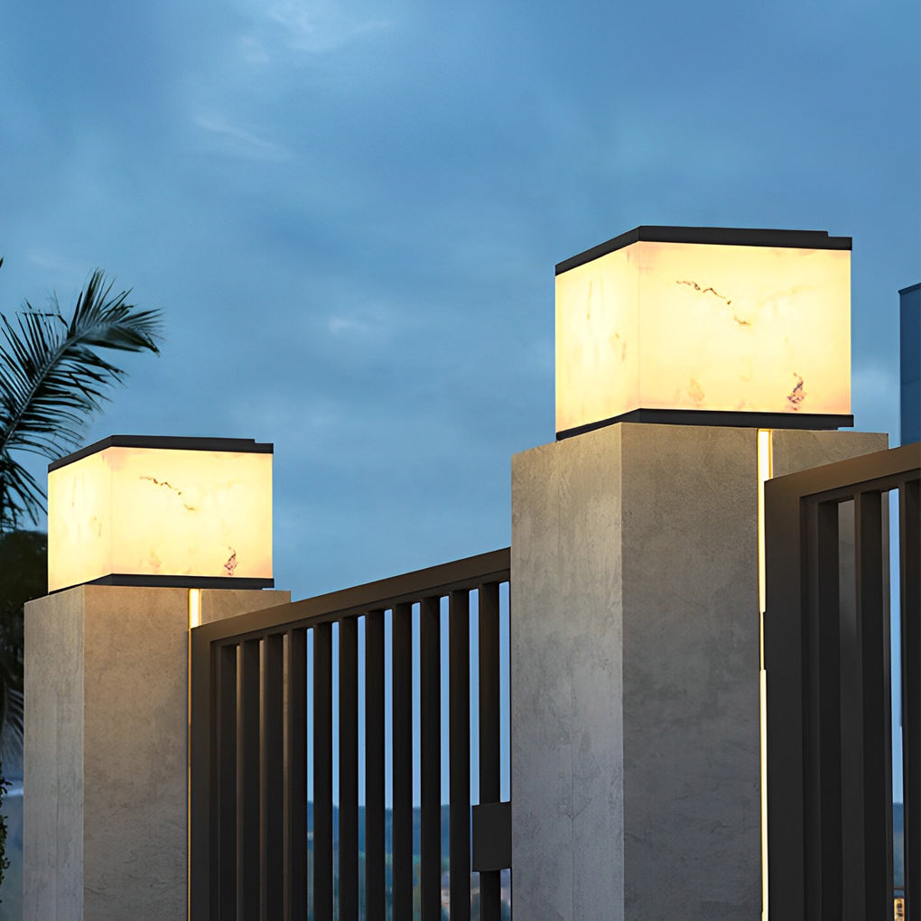 Outdoor stone pillar lights with a soft glow, highlighting a traditional garden at dusk.