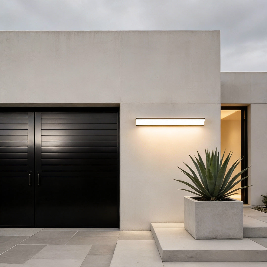 Outdoor wall light fixture installed near a garage entrance for functional exterior lighting.