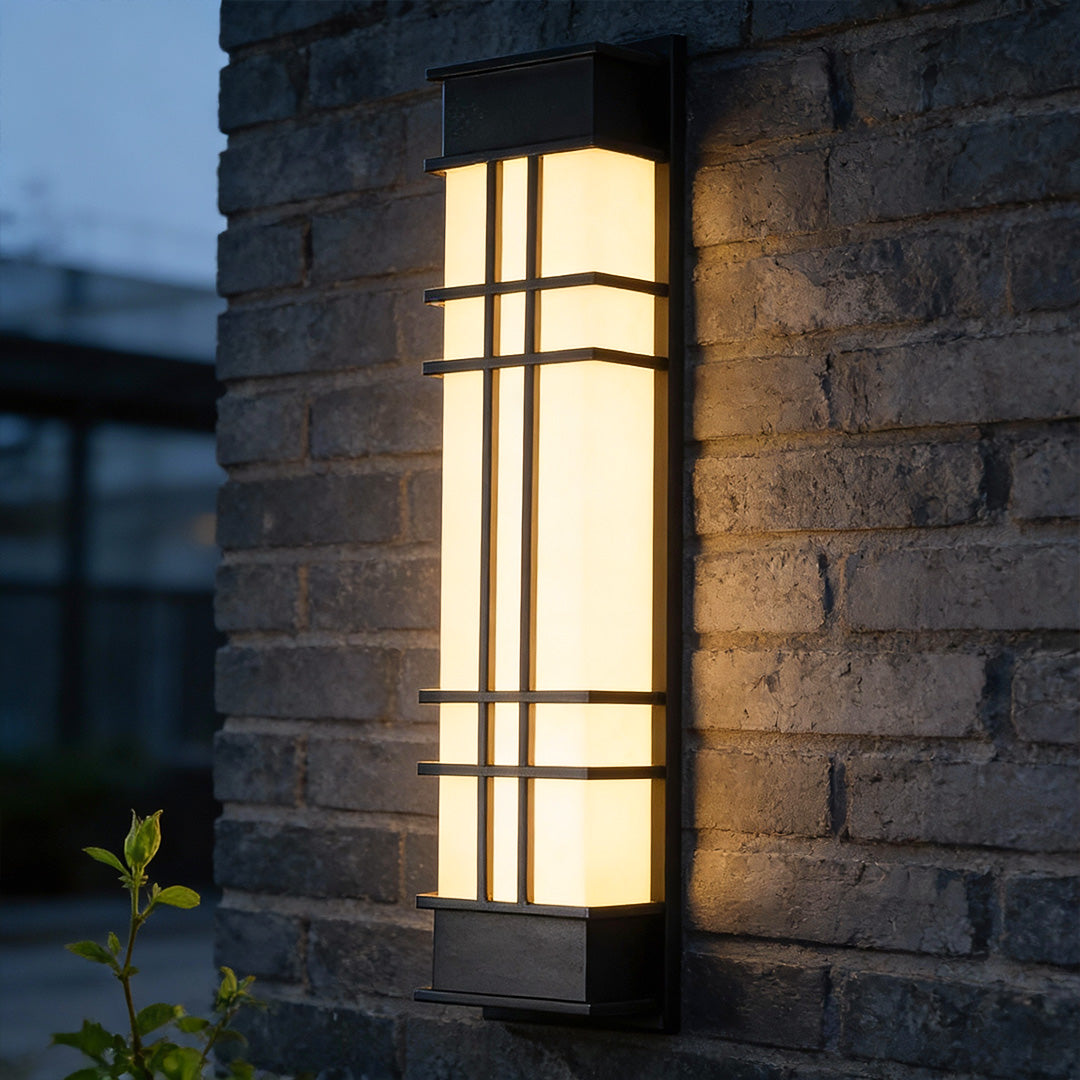 Outdoor wall sconce black installed on a brick wall, providing warm illumination.