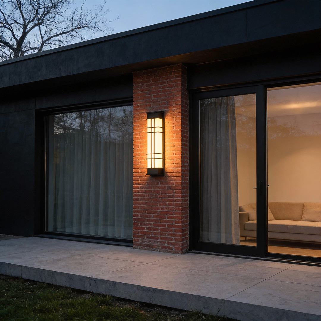 Outdoor wall sconce black with rectangular design, mounted beside a modern house entrance.
