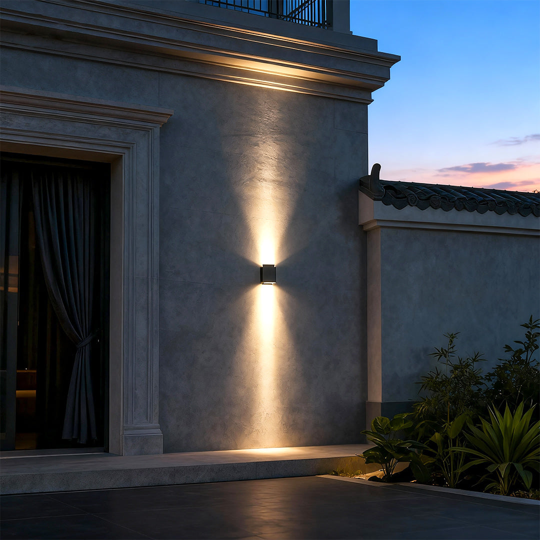 LED outdoor wall wash lights shining on a rustic brick wall at night.